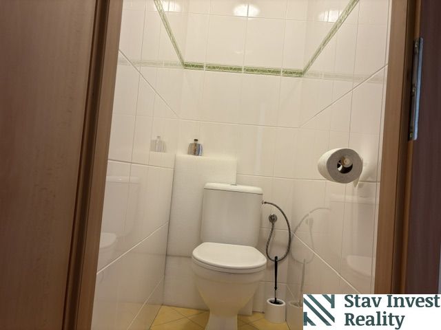 Toilet in a 4-room apartment with white tiles and a toilet.