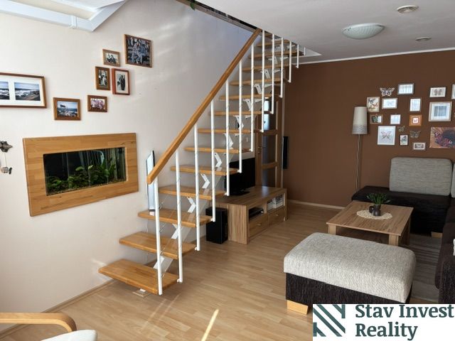 Living room with stairs, wooden decor flooring, and wall decoration in a 4-room apartment.