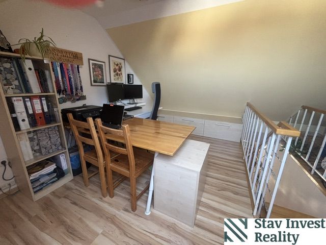 Attic office with a desk and drawers in a 4-room apartment with a wooden decor floor.