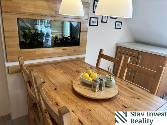 Dining area in a 4-room apartment with a table and a decorative aquarium on the wall.