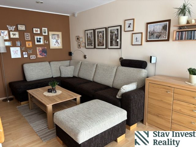Living room in a 4-room apartment with a comfortable sofa and a floor with a wooden decor.