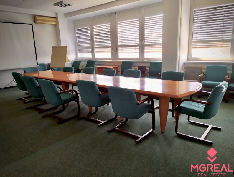 Meeting room with a large table and green chairs in the offices.