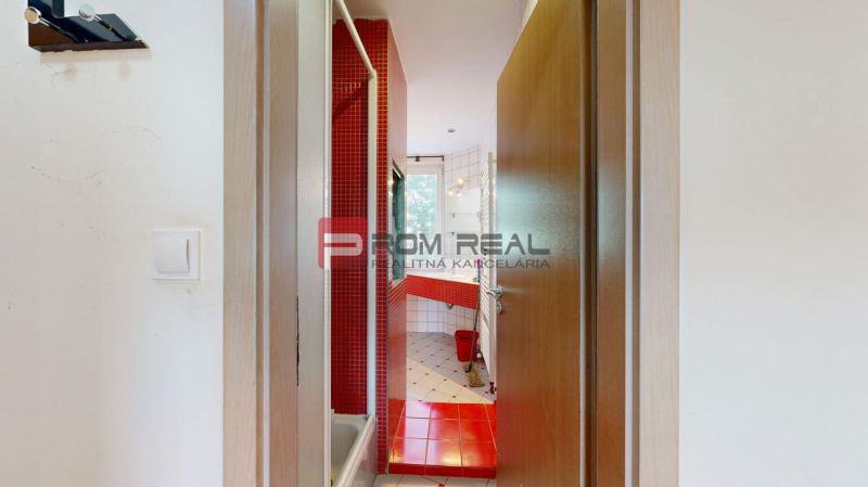 A bathroom in a 3-room apartment with red tiles and a window.