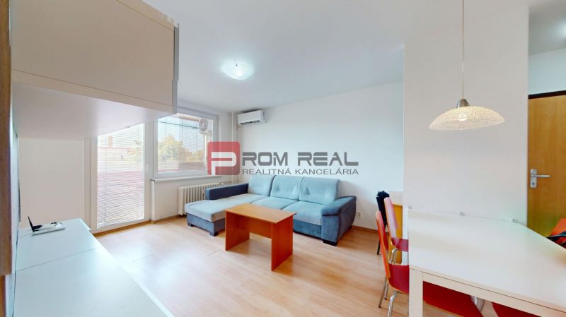 Living room in a 3-room apartment with a sofa, table, and wooden decor flooring.