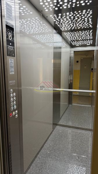 The interior of an elevator in a 3-room apartment with modern lighting and a control panel.