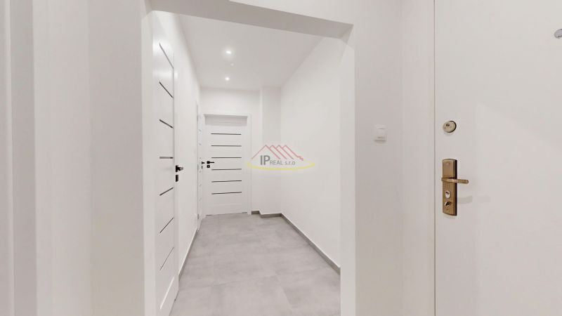 A hallway in a 3-room apartment with white walls and tiled floor.