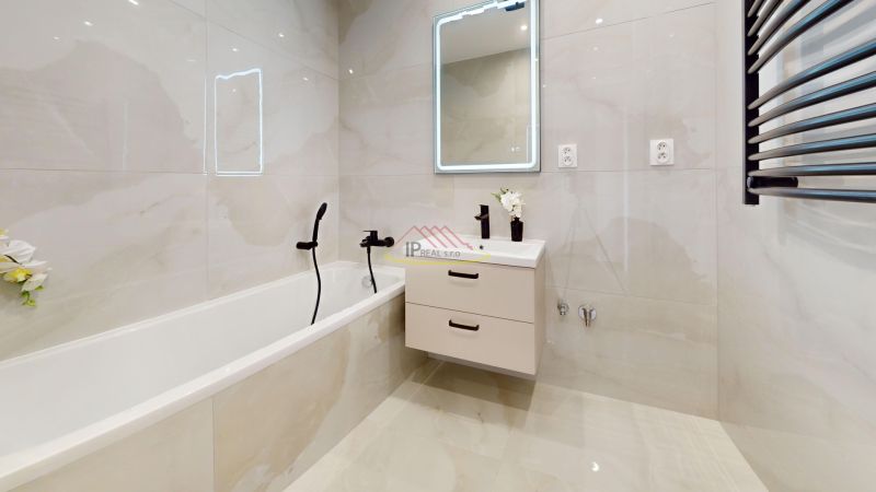 A bathroom with a bathtub, mirror, and cabinet in a 3-room apartment.