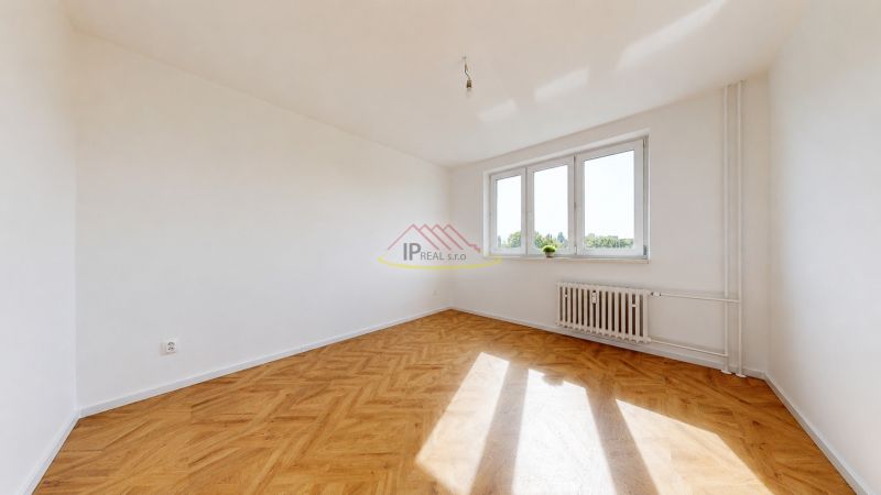 A room with a wooden floor decor and a large window in a 3-room apartment.