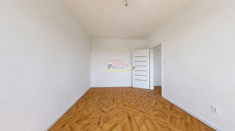 Spacious room in a 3-room apartment with a wooden decor floor.