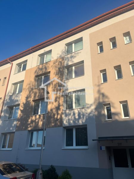 An apartment building in Rožňava offering a 2-room apartment under a clear sky.