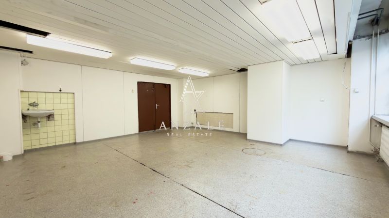 Spacious rooms with white walls, lighting, and a sink in warehouses and halls.