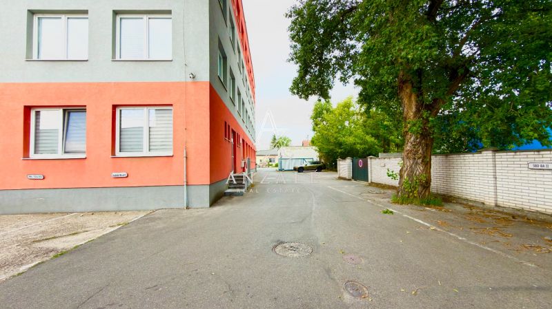 Exterior on Strojnícka Street in Ružinov near warehouses and halls, next to a tree and a building.