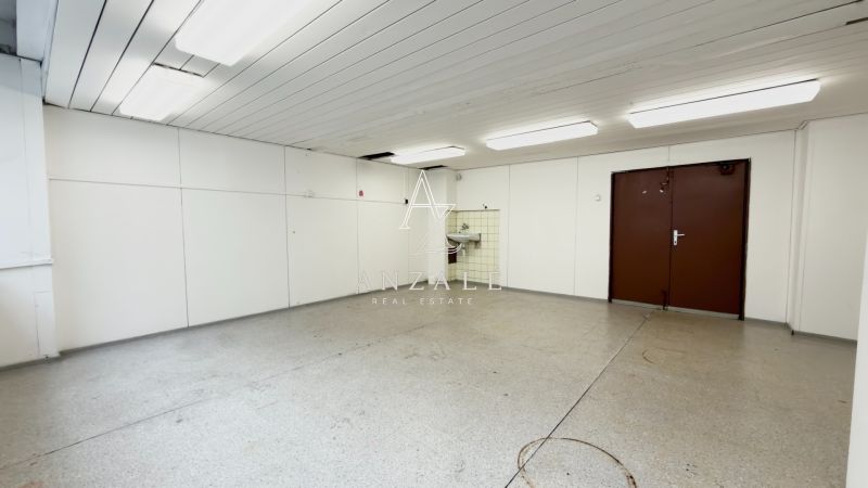 An empty storage space with a sink and white walls in Warehouses and halls.