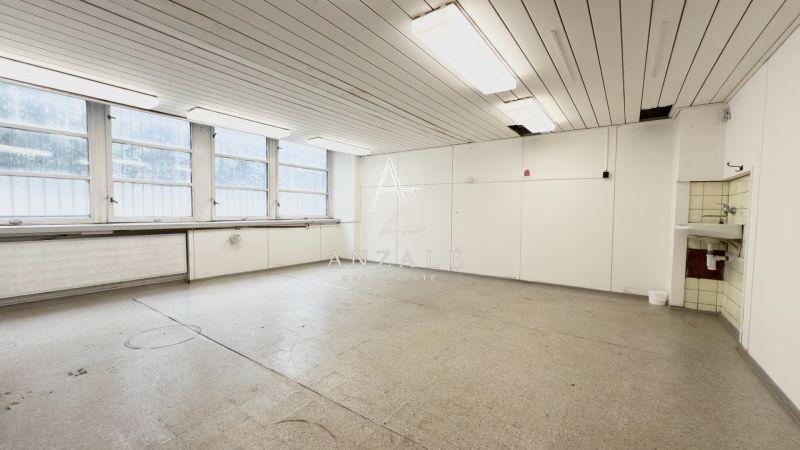 A bright room with four large windows and a sink, suitable for storage and halls.