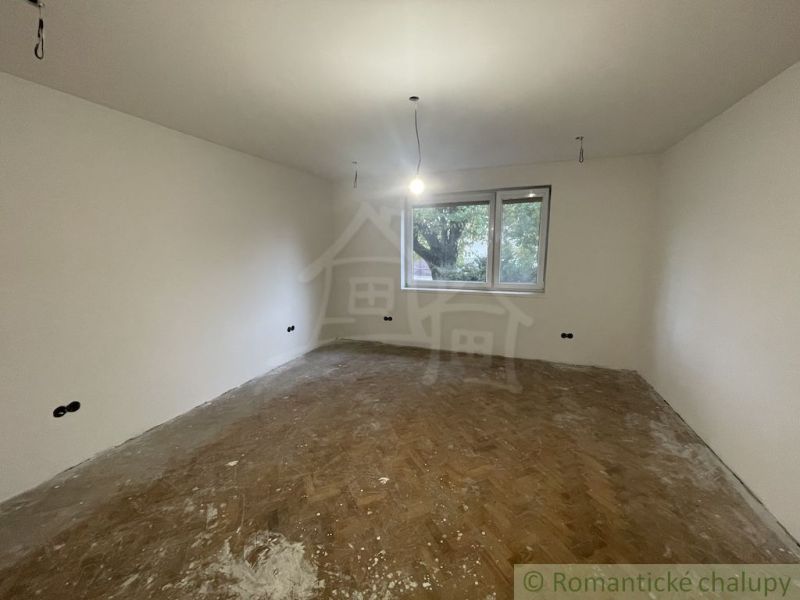 A spacious room with a wooden decor floor in a family house.