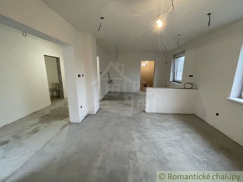 The interior of a family house with plastered walls and a cement floor.