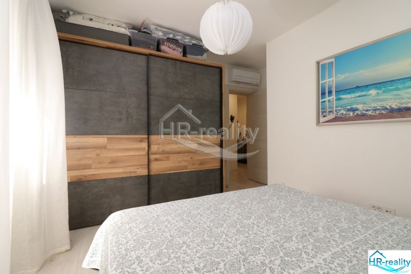 Bedroom with a large wardrobe and a picture of a beach in a holiday apartment.
