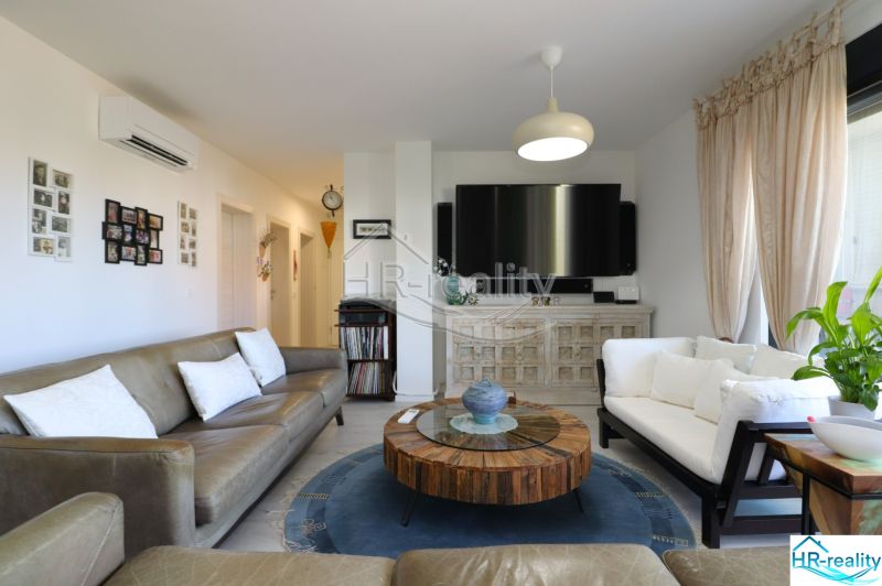 Living room in a holiday apartment with comfortable sofas and a television.