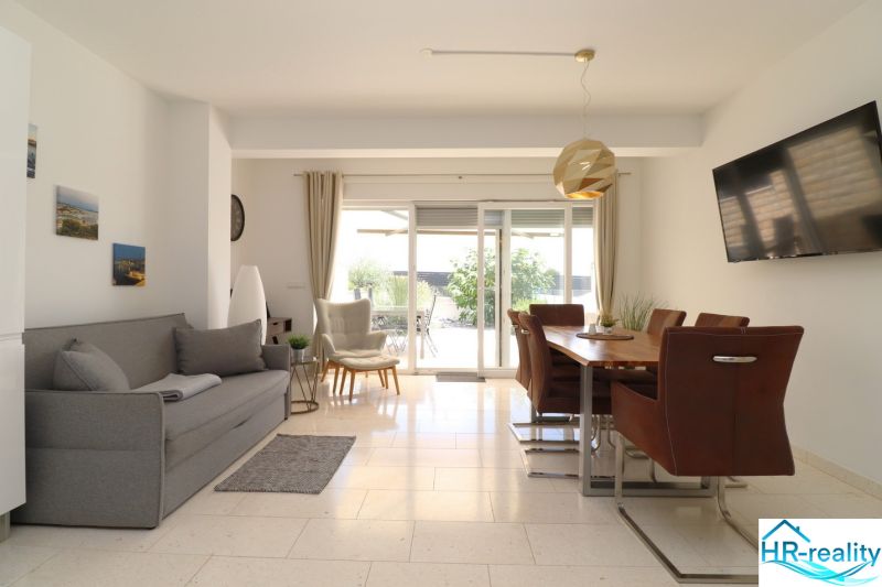 Living room in a holiday apartment with comfortable seating and a dining table.