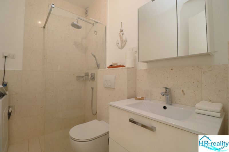 A bathroom in a holiday apartment with a modern shower and sink.