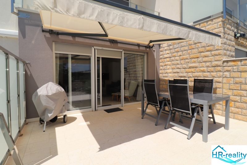 The terrace of a recreational apartment in Tribunj with covered seating and outdoor furniture.