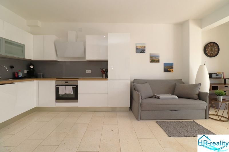 A kitchen with a sofa in a holiday apartment, wooden decor flooring, tasteful decorations.