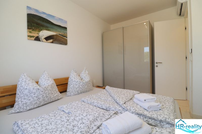 Bedroom in a holiday apartment with a double bed, wardrobe, and decorative painting.