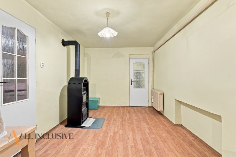 Interior of a family house with a wooden decor floor and a black tiled stove.
