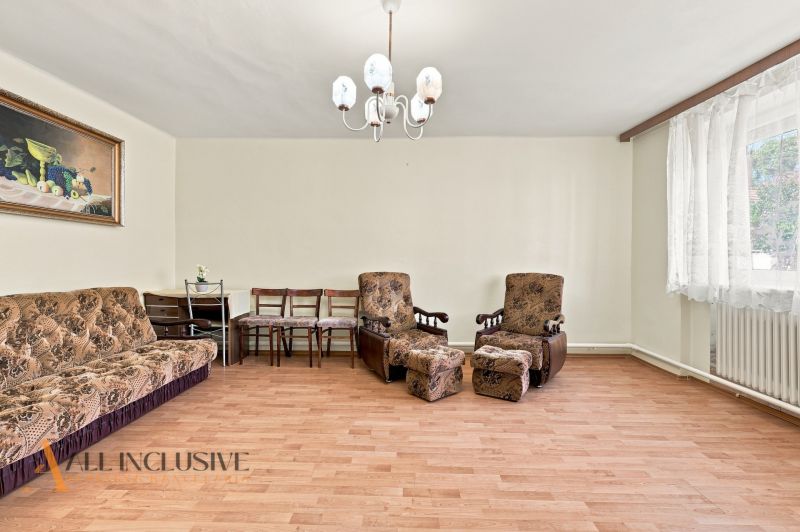 Living room in a family house with a wooden decor floor, complemented by upholstered furniture.