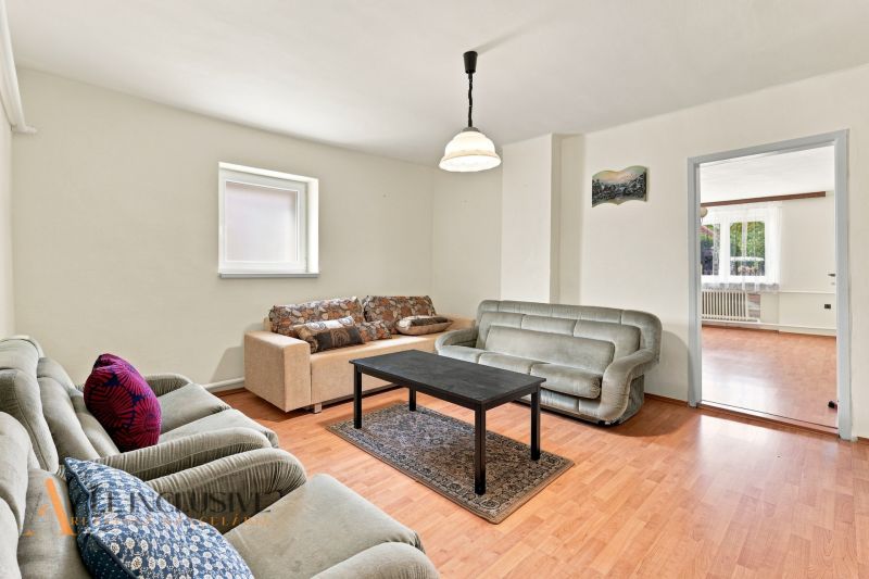 Living room of a family house with a comfortable sofa set and a coffee table on a floor with a wooden decor.