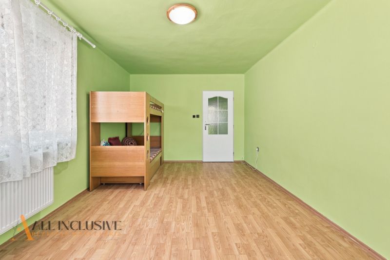 Green room with a bunk bed and wood-patterned flooring in a family house.