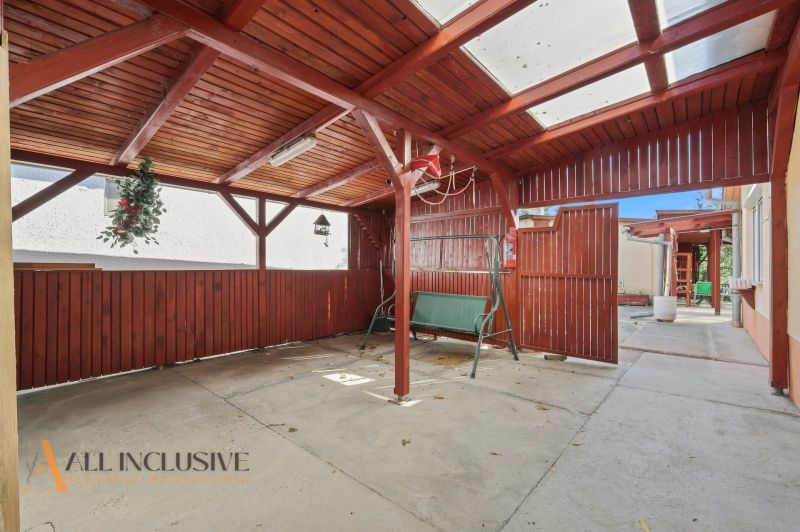A terrace with a wooden gazebo at a family house in Veľký Meder, with a swing and decorations.