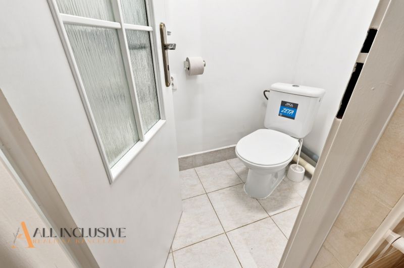 Small bathroom in a family house with a toilet and white walls.