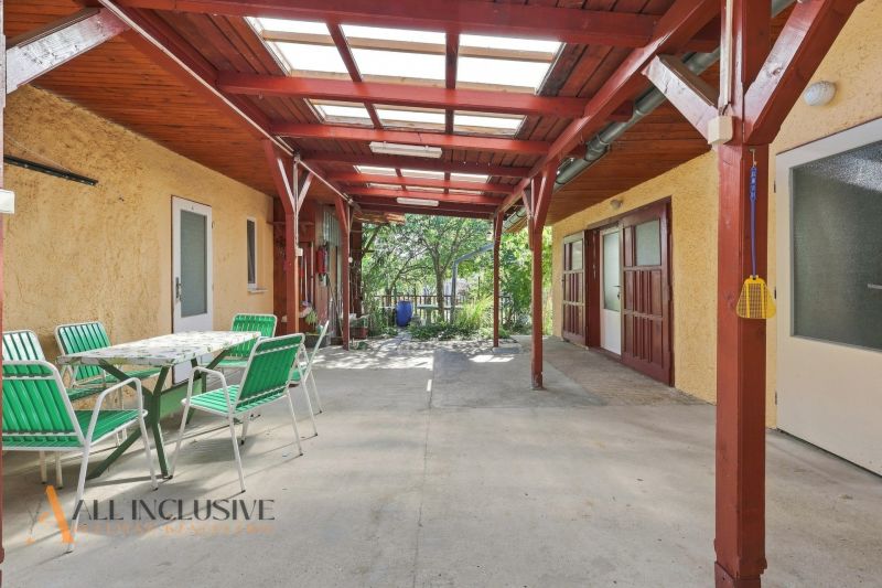 Covered terrace of a family house in Veľký Meder with green chairs and a table.