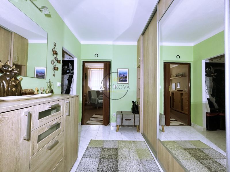 A classic hallway with green walls in a 4-room apartment with a large mirror.