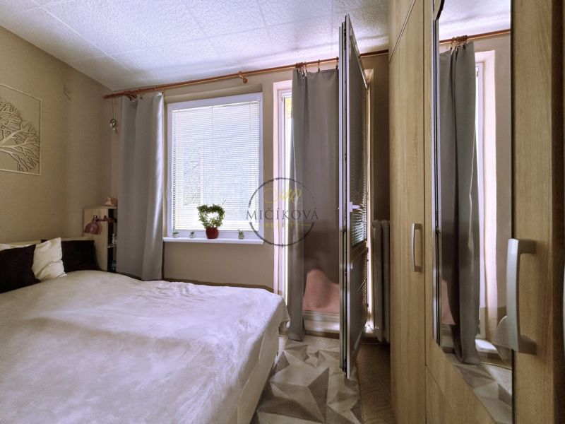 Bedroom in a 4-room apartment with a bed, window, and wardrobe.