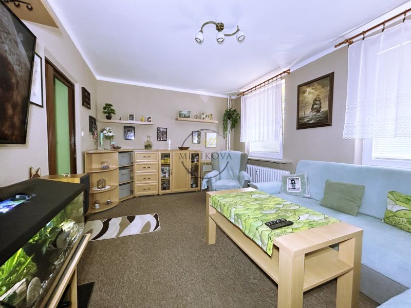 Living room in a 4-room apartment with a sofa, aquarium, and shelves.