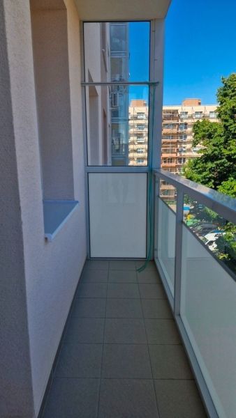 Glazed loggia with tiles in a 3-room apartment, view of the external architecture.