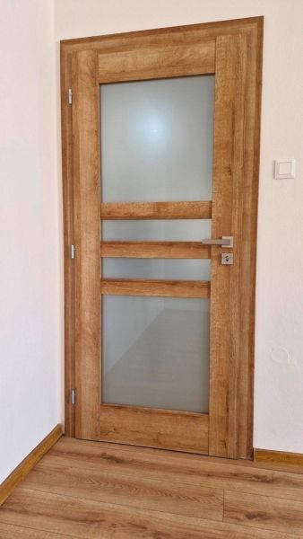 Interior doors with wood decor and frosted glass in a 3-room apartment.