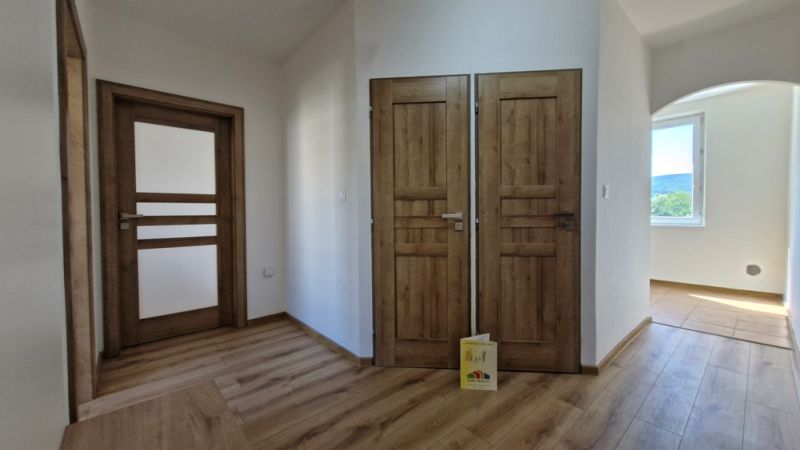 Interior of a 3-room apartment with a wooden decor floor and wooden doors.