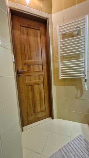 Bathroom interior in a 3-room apartment with wooden doors and a ladder radiator.