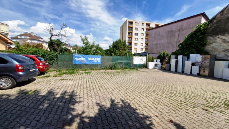 Parking lot on Piešťanská Street in Nové Mesto nad Váhom, surrounded by buildings and greenery.