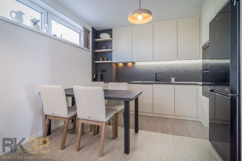 Kitchen in a 4-room apartment, wooden decor flooring, light cabinets, and a dining table.