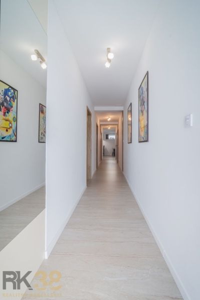 A hallway with light-colored walls and a wooden decor floor in a 4-room apartment.