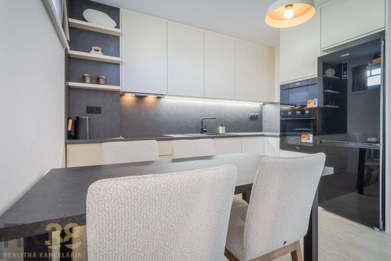 A kitchen in a 4-room apartment with a dining table and a wooden decor floor.