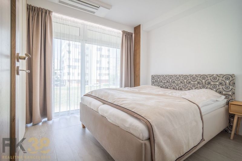 Bright bedroom in a 4-room apartment with large windows and a bed.