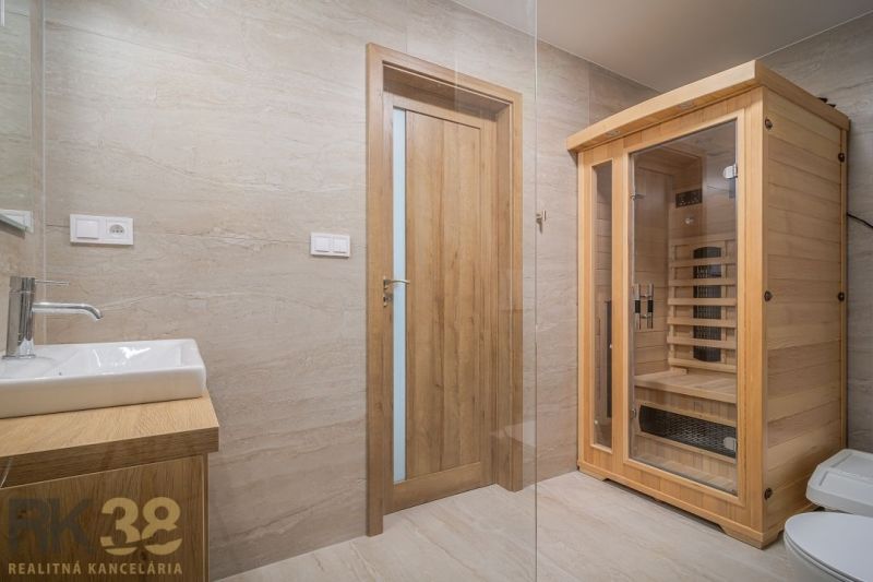 Bathroom with a sauna in a 4-room apartment with wooden decor and a sink.