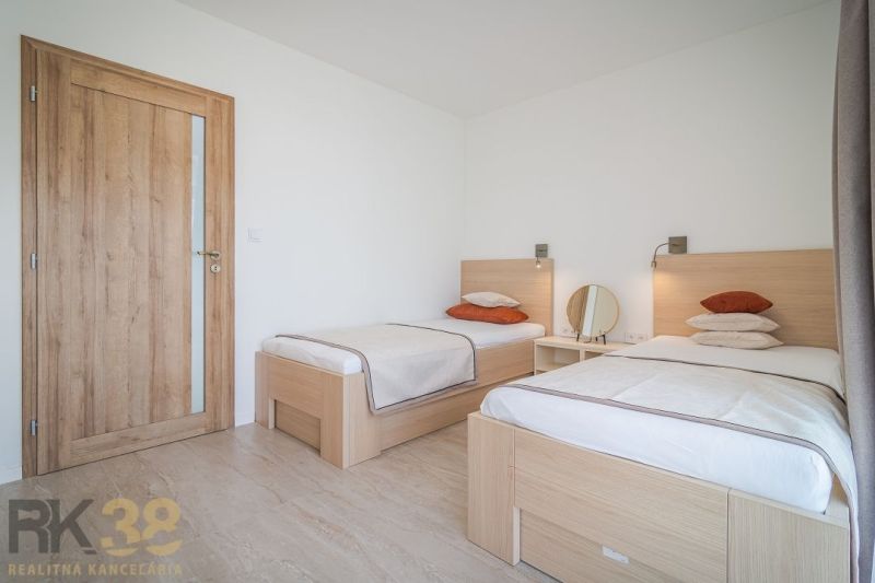 A bright bedroom in a 4-room apartment with two single beds and wooden decor.