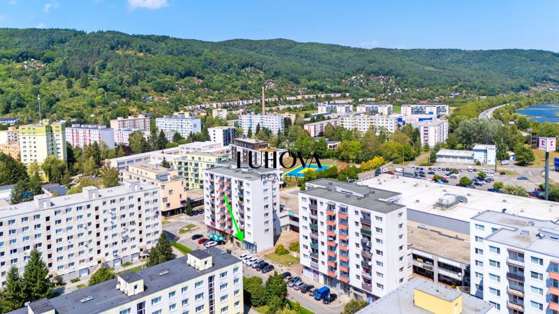 A view of the commercial premises at Dvory in Púchov with nearby greenery and rooftop parking.