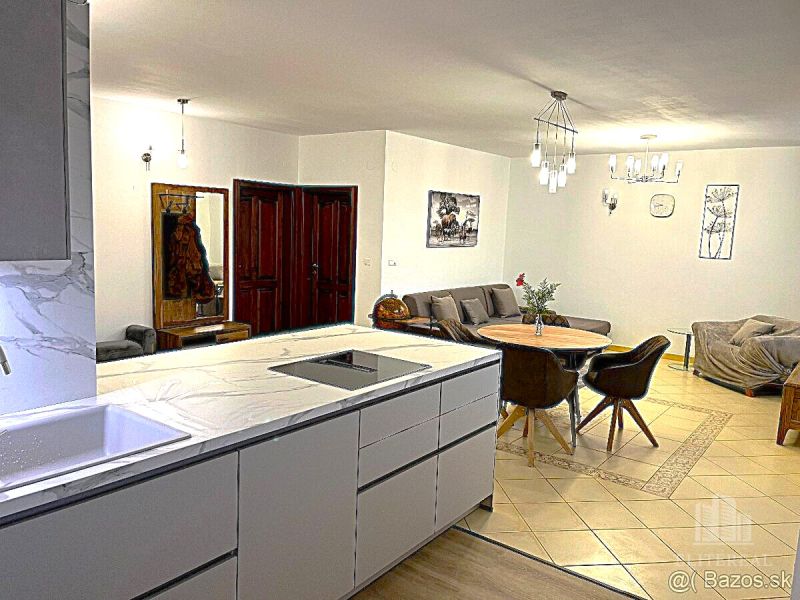 Kitchen and living room in a 3-room apartment with a kitchen counter and dining table.